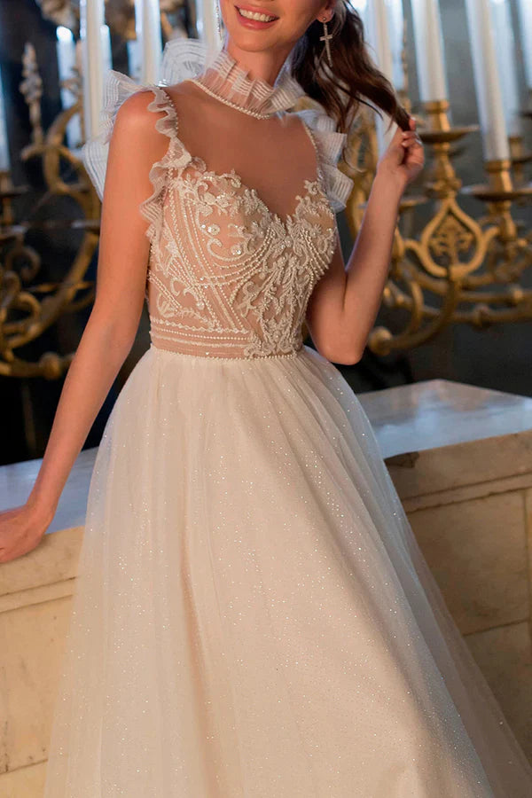 A bohemian wedding dress with a thread illusion and sparkling beads at the neckline